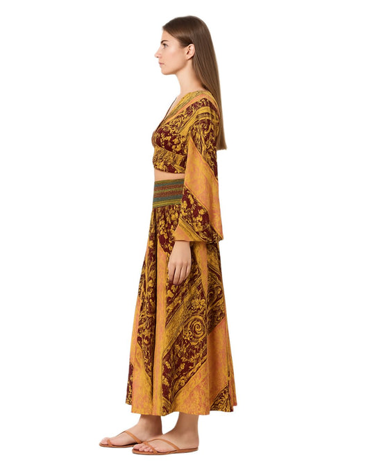 Woman wearing a mustard yellow and brown patterned outfit on a white background
